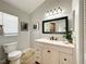 Bright bathroom with a white vanity, black framed mirror, stylish lighting and tiled floors at 10360 Crystal Point Dr, Orlando, FL 32825
