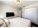 Well-lit bedroom featuring a comfortable bed, closet, and mounted TV for entertainment at 10360 Crystal Point Dr, Orlando, FL 32825