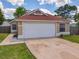 Attractive single-story home featuring a two-car garage, well-kept lawn, and neat landscaping at 10360 Crystal Point Dr, Orlando, FL 32825