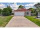 Charming single-story home with a well-maintained lawn, long driveway, and attached two-car garage at 10360 Crystal Point Dr, Orlando, FL 32825