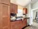 Galley kitchen featuring dark wood cabinetry, stainless dishwasher and granite countertops at 10360 Crystal Point Dr, Orlando, FL 32825