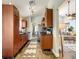 Bright galley kitchen with wood cabinetry, stainless appliances and views to the living room at 10360 Crystal Point Dr, Orlando, FL 32825