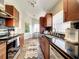 Updated galley kitchen featuring dark countertops, stainless steel appliances, and bar seating at 10360 Crystal Point Dr, Orlando, FL 32825