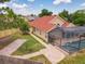 Aerial view of a home with a screened pool, brick-paved patio, neatly maintained lawn, and neutral colored exterior at 10360 Crystal Point Dr, Orlando, FL 32825