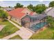 Aerial view showcases a home with a screened pool, beautiful pavers, and neutral toned exterior at 10360 Crystal Point Dr, Orlando, FL 32825