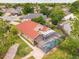 Aerial view of a screened in pool area featuring brick pavers, with a terracotta colored roof and lawn at 10360 Crystal Point Dr, Orlando, FL 32825