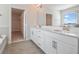 Bright bathroom featuring double sinks, granite countertop, and walk-in closet at 11027 Hollow Bay Dr, Winter Garden, FL 34787