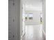Bright hallway with wood-look tile flooring, leading to a view of the lake at 11027 Hollow Bay Dr, Winter Garden, FL 34787