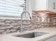 Elegant kitchen sink with a modern faucet and a backsplash with a stylish tile design at 11027 Hollow Bay Dr, Winter Garden, FL 34787