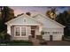Charming home features light blue shingles, stone accents, two-car garage, and well-maintained landscaping at 11045 Hollow Bay Dr, Winter Garden, FL 34787