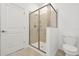 Tiled bathroom featuring a glass enclosed shower, white toilet, and tile floors at 11288 Listening Dr, Orlando, FL 32832