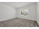 Bedroom with neutral carpet, bright natural light from window, and simple white walls at 11288 Listening Dr, Orlando, FL 32832