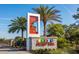 Community sign with palm trees, lush landscaping, and inviting entrance to the neighborhood at 11288 Listening Dr, Orlando, FL 32832