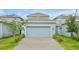 Attached two-car garage with a paved driveway, offering convenient parking and extra storage space at 11288 Listening Dr, Orlando, FL 32832
