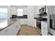 Close-up of the kitchen featuring stainless steel appliances, white cabinets, and an island with stone countertops at 11288 Listening Dr, Orlando, FL 32832