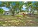 Expansive backyard with large shade trees, a playset, and privacy fence, ideal for Gathering fun and outdoor enjoyment at 1210 Quintuplet Dr, Casselberry, FL 32707