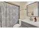 Well-lit bathroom with a shower-tub combo featuring a patterned curtain and a vanity with modern faucet fixtures at 1210 Quintuplet Dr, Casselberry, FL 32707