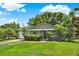 Charming one-story home with lush green lawn, mature landscaping, and a black front door at 1210 Quintuplet Dr, Casselberry, FL 32707