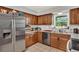 Bright kitchen featuring stainless steel refrigerator, granite countertops, and light brown cabinets at 1210 Quintuplet Dr, Casselberry, FL 32707