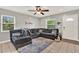 Bright living room featuring a large sectional sofa, ceiling fan, and neutral color palette at 1210 Quintuplet Dr, Casselberry, FL 32707