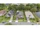 Aerial view of three upscale homes, lush landscaping, well-maintained yards and neighborhood pond at 1265 Estancia Woods Loop, Windermere, FL 34786
