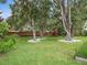 Well-maintained backyard featuring a playground, mature trees and lush green grass for play and leisure at 1265 Estancia Woods Loop, Windermere, FL 34786