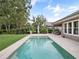 Backyard view with pool and artificial turf, patio and mature landscape at 1265 Estancia Woods Loop, Windermere, FL 34786