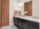 Bathroom featuring dark wood cabinets, double sinks, marble countertops, and modern lighting fixtures at 1265 Estancia Woods Loop, Windermere, FL 34786