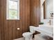 Chic powder room features a wood-paneled wall, floating vanity, modern sink, and designer toilet at 1265 Estancia Woods Loop, Windermere, FL 34786