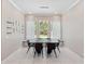 Bright dining room featuring a modern table set, natural light from the large windows, and clean, minimalist decor at 1265 Estancia Woods Loop, Windermere, FL 34786
