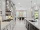 Spacious kitchen with white cabinets, stainless steel appliances, a granite island, and an adjacent dining area with backyard views at 1265 Estancia Woods Loop, Windermere, FL 34786