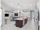 Open-concept kitchen with a large central island, granite countertops, stainless steel appliances, and a seamless flow into the living area at 1265 Estancia Woods Loop, Windermere, FL 34786