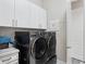Modern laundry room features LG washer and dryer, white cabinets, and neutral walls at 1265 Estancia Woods Loop, Windermere, FL 34786
