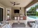 Relax in this outdoor living space with a built-in kitchen and serene backyard view at 1265 Estancia Woods Loop, Windermere, FL 34786