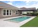 Relaxing backyard view of pool and travertine patio with a covered outdoor dining area at 1265 Estancia Woods Loop, Windermere, FL 34786