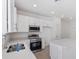 Well-lit kitchen has white cabinets, stainless appliances, and an island with quartz countertop at 1267 Stockwell Ave, St Cloud, FL 34771