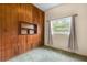 Cozy bedroom with wood-paneled wall, built-in shelves, and a bright window at 137 W Lauren Ct, Fern Park, FL 32730
