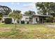 Single-story home with a covered carport and landscaped front yard showcasing mature trees at 137 W Lauren Ct, Fern Park, FL 32730
