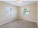 Well lit bedroom features neutral paint, two windows, neutral carpet, and base trim at 1417 Pine Lake Rd, Orlando, FL 32808