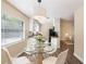 Modern dining area featuring a glass table and white chairs with large windows at 1417 Pine Lake Rd, Orlando, FL 32808