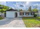 Charming single-story home with light blue paint, neat front lawn, and welcoming arched entryway at 1417 Pine Lake Rd, Orlando, FL 32808