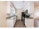 Charming kitchen with white cabinets, stone counters and modern appliances at 1417 Pine Lake Rd, Orlando, FL 32808