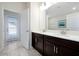 Bathroom boasts double sinks, dark cabinets, and access to an exterior patio at 1521 Flange Dr, Davenport, FL 33896