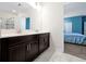 Bathroom with double sinks, dark cabinetry, and marble tile flooring, offering a stylish design at 1521 Flange Dr, Davenport, FL 33896