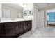Bright bathroom featuring modern fixtures, double sinks, and hallway access to the bedrooms at 1521 Flange Dr, Davenport, FL 33896