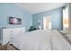 Light blue bedroom with a king-size bed, television, and white dresser at 1521 Flange Dr, Davenport, FL 33896