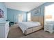 Bright bedroom featuring a king-size bed, soft blue walls, and a large window for natural light at 1521 Flange Dr, Davenport, FL 33896
