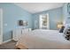 Light blue bedroom with a king bed, a television, and a large window at 1521 Flange Dr, Davenport, FL 33896
