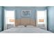 Bedroom with a neutral headboard, white comforter, and matching nightstands under a pair of windows at 1521 Flange Dr, Davenport, FL 33896