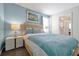 Comfortable bedroom featuring calming blue tones, soft bedding, and a well-lit ensuite bathroom at 1521 Flange Dr, Davenport, FL 33896